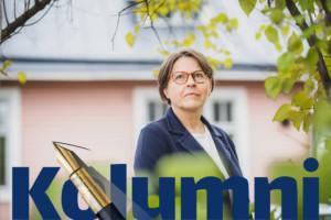 Europarlamentaarikko Heidi Hautala seisoo ulkona taustalla talo.