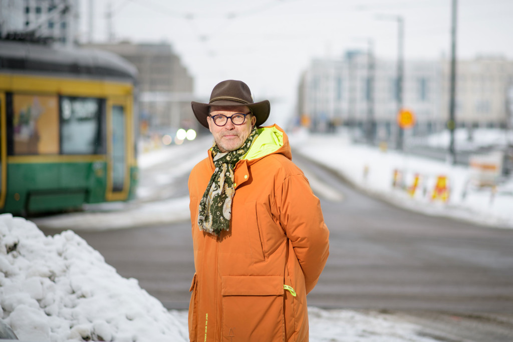 Uudenmaan liiton maakuntajohtaja Ossi Savolainen seisoo kadulla ja taustalla ratikka.